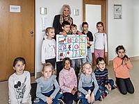 Sonja Habermeier, Fachaufsicht im Amt für Kinderbetreuung freut sich sichtlich über das Bild für die kahlen Bürowände. Foto: Kath. Kita IN gGmbH